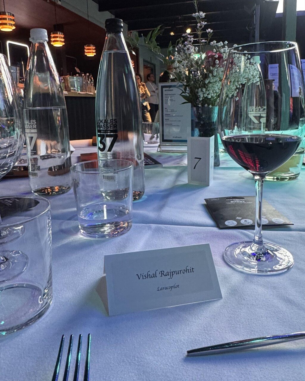 A place card reading "Vishal Rajpurohit, LaraCopilot" at Table 7 of the Executive Dinner Zurich, set with water, wine and a table-seven marker.