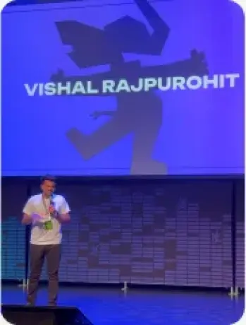 Vishal Rajpurohit on stage under a screen displaying his name